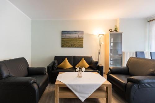 a living room with two couches and a table at Mayglück App 1 in Norderney