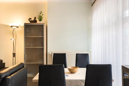 a dining room with a table and chairs at Mayglück App 1 in Norderney