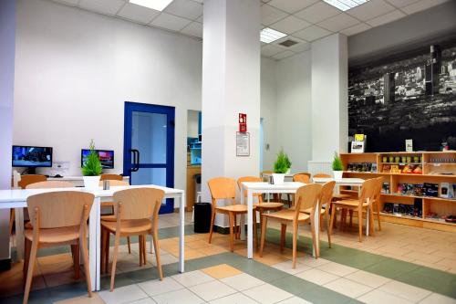 a dining room with tables and chairs and a chalkboard at Warsaw Hostel Centrum Private Rooms & Dorms in Warsaw