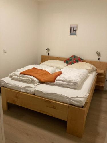 a large bed with a wooden frame in a bedroom at Fewo Paul in Glowe