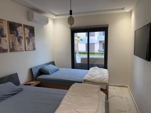 Postel nebo postele na pokoji v ubytování Superbe appartement 120 mc, Plage à pieds, 3 piscines & calme garanti - Sidi Rahal Plage