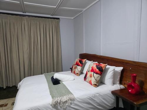 a bedroom with a bed with white sheets and pillows at Nandoni Maritime Home in Thohoyandou