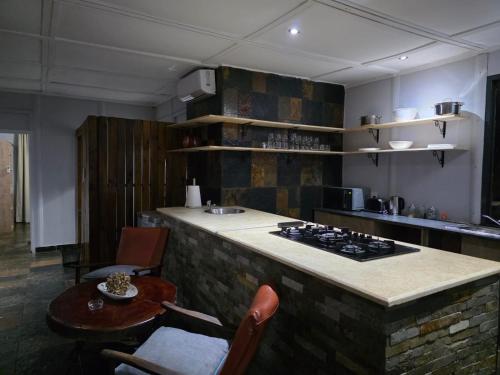 a kitchen with a counter with a stove and a table at Nandoni Maritime Home in Thohoyandou