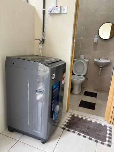 a small bathroom with a toilet and a washing machine at EcoPutra Stay in Ipoh
