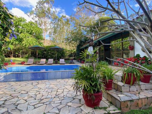 una casa con piscina con sedie e piante di Vila Maria - Linda Casa de Campo a Rio de Janeiro