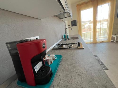 a red coffee maker sitting on a counter in a kitchen at Casa Via Marconi in Assemini