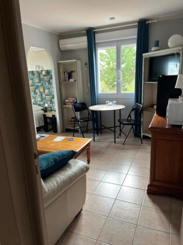 un soggiorno con un tavolo e una sala da pranzo di Suite pour Adultes a Combaillaux