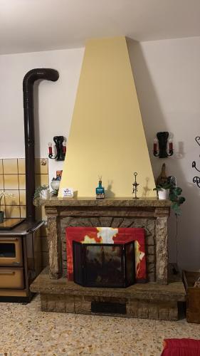 un salon avec une cheminée en pierre avec dans l'établissement La casa di Nonna nel Piazzalino Asciano Siena Crete Senesi, à Asciano