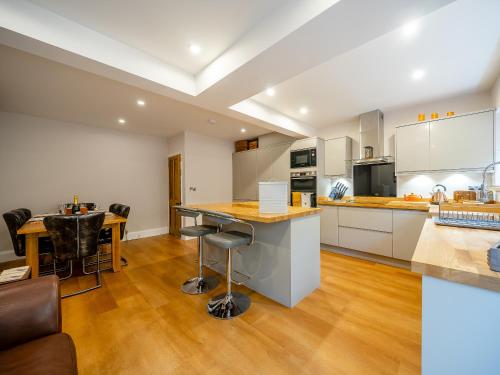 a large kitchen with white cabinets and a table at Hare Bee & Bee in Stratford-upon-Avon