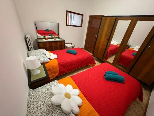 une chambre avec deux lits et un miroir dans l'établissement La casa di Nonna nel Piazzalino Asciano Siena Crete Senesi, à Asciano