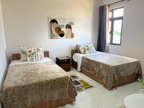 a bedroom with two beds and a window at Coastal Blue Apt 7 in Flic-en-Flac