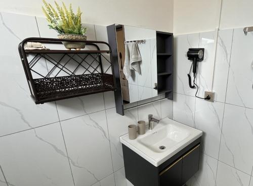 a white bathroom with a sink and a mirror at Coastal Blue Apt 7 in Flic-en-Flac