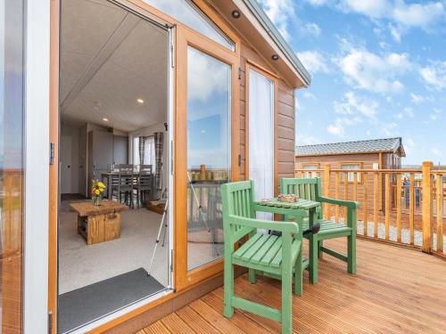 a patio with two chairs and a table on a deck at Burray in Mey
