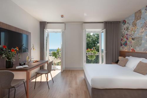 法诺Openhouse Stay的酒店客房设有一张床和一张书桌,还有一间享有美景的客房。