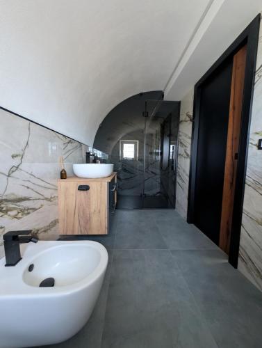 a bathroom with a large white tub and a sink at Appartamento Dar Per in Lavarone
