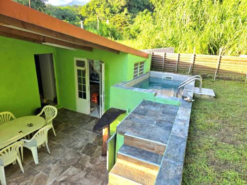 a green house with a hot tub on a patio at L'Orange Volcanique in Saint-Pierre
