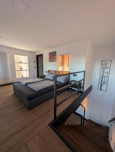 a large bedroom with a bed and a staircase at Appartamento Dar Per in Lavarone