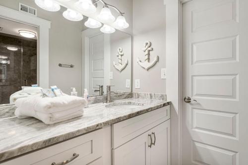 a white bathroom with a sink and a mirror at Mermaid's Den in Panama City Beach