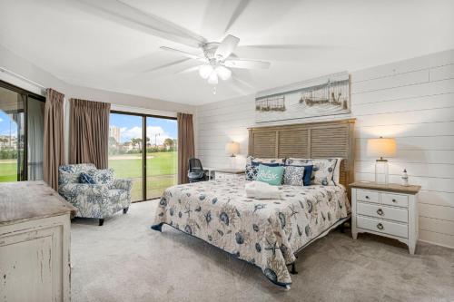 a bedroom with a bed and a ceiling fan at Mermaid's Den in Panama City Beach