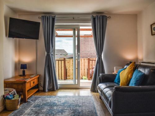 ein Wohnzimmer mit Couch und großem Fenster in der Unterkunft Cayton Cove Cottage in Cayton