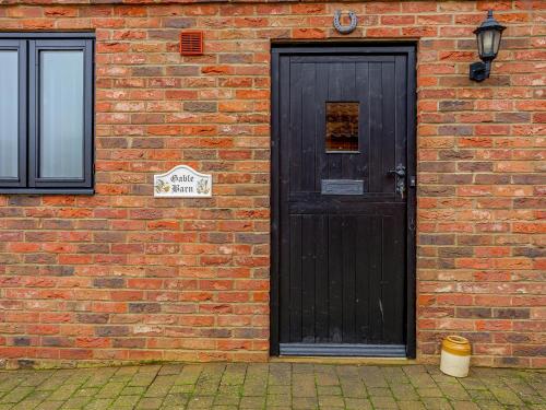 Runcton HolmeにあるGable Barn - E3865のレンガ造りの建物側の黒い扉