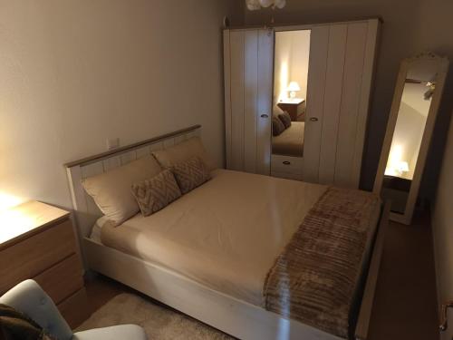 ein Schlafzimmer mit einem großen Bett und einem Spiegel in der Unterkunft Casa vacanza - Ambra's Homes in Trinità dʼAgultu