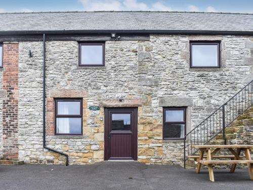 a stone building with a brown door and a staircase at Haddon Cottage - Uk40270 in Bakewell