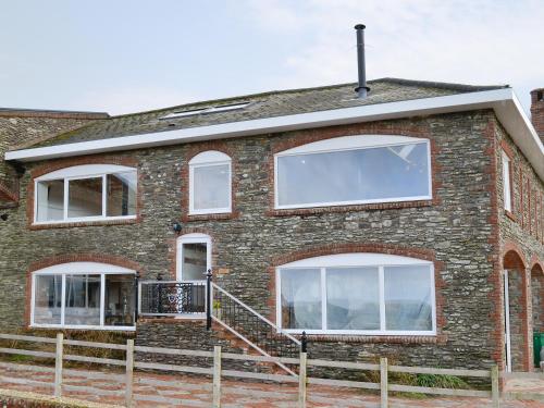 a brick house with white windows and a staircase at Coombe View in South Redworthy