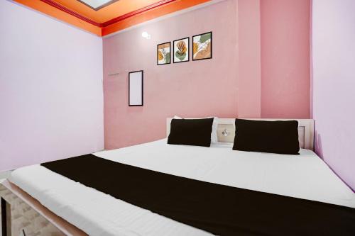 a bedroom with a large bed in a pink room at SPOT ON Pradhan Hotel in Bhīta