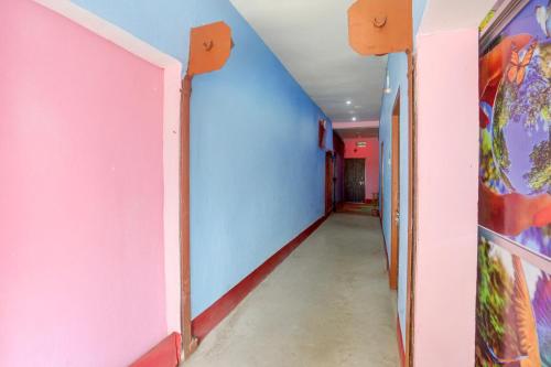 an empty hallway with pink and blue walls at spot On Happy Awashi Hotel in Patna City