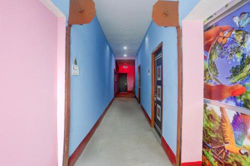 a hallway with blue walls and a red ceiling at spot On Happy Awashi Hotel in Patna City