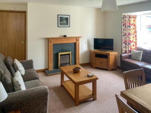a living room with a couch and a fireplace at 1 Lonsdale House in Keswick