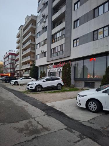 una fila di auto parcheggiate davanti a un edificio di Promenada Wiew a Craiova