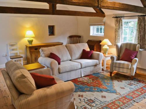 a living room with a couch and two chairs at The Old Stables in Cley next the Sea