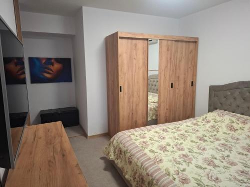 una camera da letto con un letto e una porta di legno di Promenada Wiew a Craiova