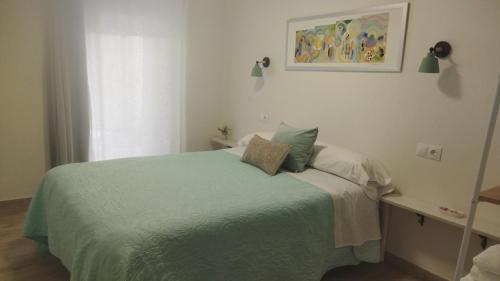 Un dormitorio con una cama con una manta verde. en Alojamiento "Destino Cazorla", en Cazorla