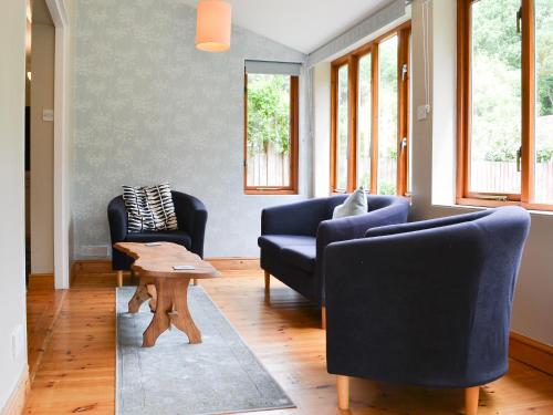 un soggiorno con due sedie blu e un tavolo di Elesa Cottage a Elsing