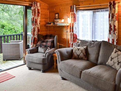 a living room with couches and chairs in a cabin at Fell View Lodge in Keswick