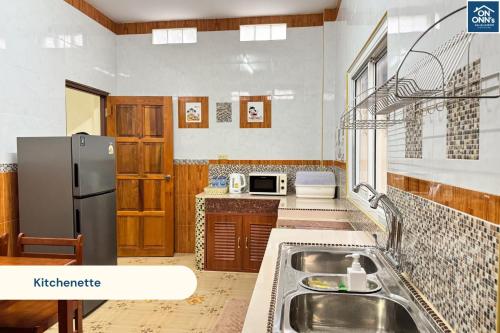 a kitchen with a sink and a refrigerator at On Onn's Guesthouse in Ban Komo Sip Paet