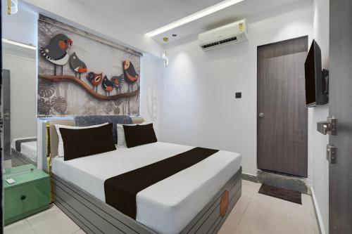 ein Schlafzimmer mit einem Bett und einem Gemälde an der Wand in der Unterkunft Hotel O Royal Fourtune in Utrān