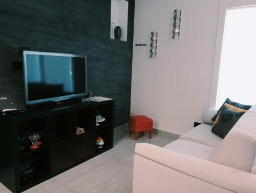 a living room with a couch and a television at Seahouse Casa vacanze Studiocantieri in Santa Flavia