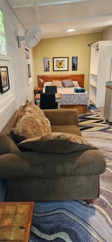 a living room with a couch and two beds at Gloria's mini hideaway in Christ Church