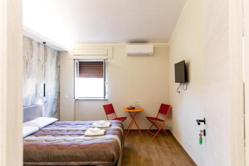 a bedroom with a bed and a table and chairs at Casa twins in Fiumicino
