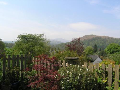 a wooden fence with flowers in a garden at Hayrake in Ambleside