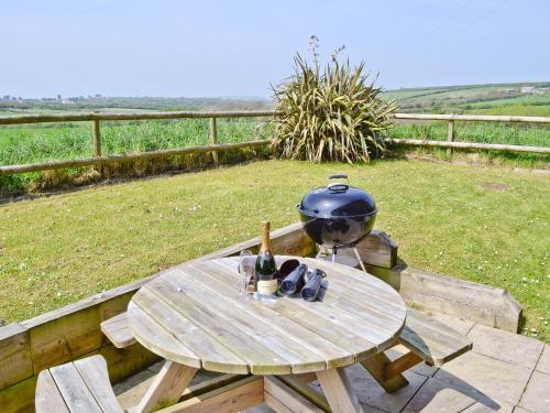 a wooden picnic table with a pot and a pot and aauldron at Harvest Cottage in Padstow