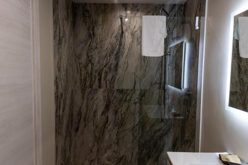 a bathroom with a shower with a stone wall at Casa twins in Fiumicino