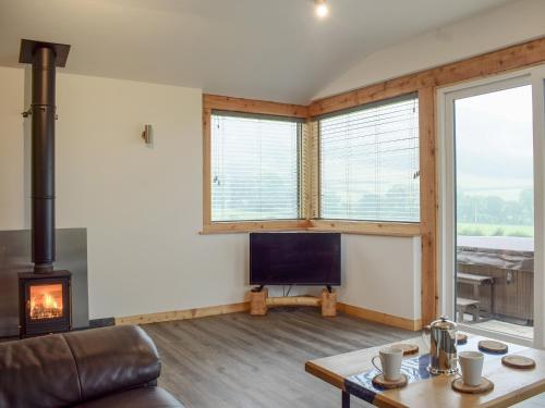 a living room with a couch and a fireplace at Llety'r Saer in Pen-y-bont-fawr