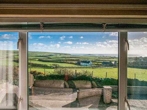 ein Fenster mit Blick auf ein grünes Feld in der Unterkunft Island View - Cottage in Aberdaron