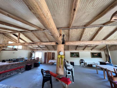 a large room with wooden ceilings and tables and chairs at Surí refugios Aquasol, Carretera Austral, Cochrane in Cochrane