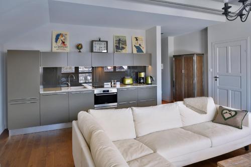 sala de estar con sofá blanco y cocina en Lemon Apartments, en Krynica-Zdrój